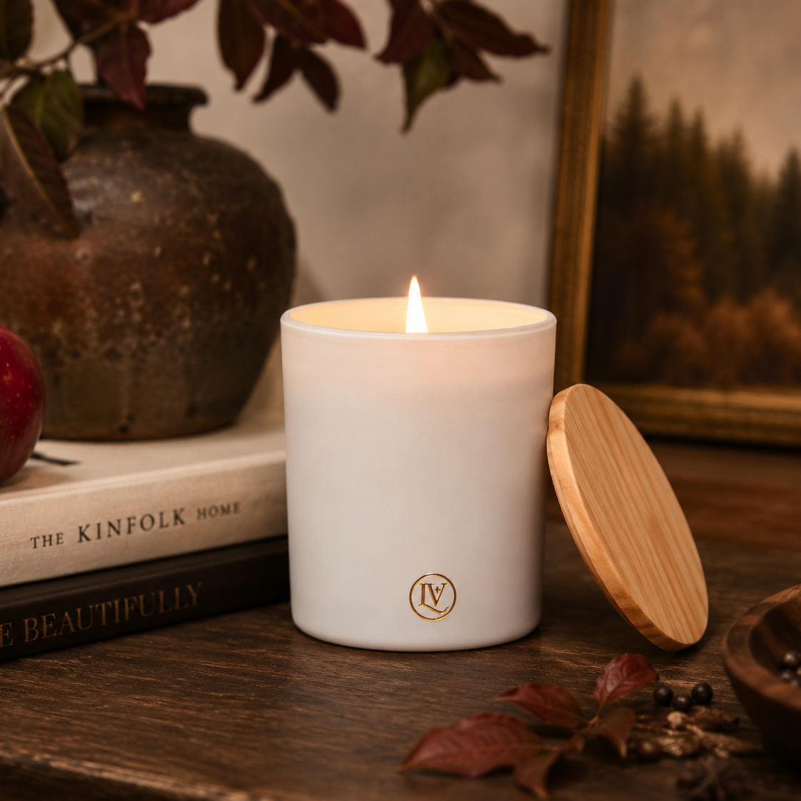 Mahogany Woods woodsy fall candle styled on a rustic wood table with cozy autumn home decor, creating a warm and inviting living space.