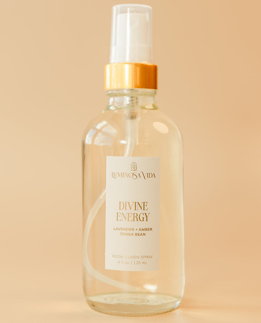 Luminosa Vida Divine Energy room and linen spray with lavender, amber, and tonka bean in a clear glass bottle.