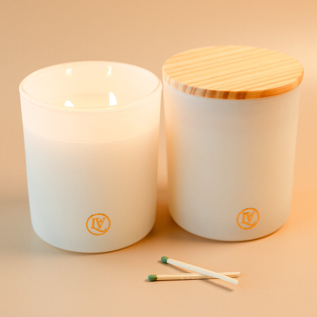 Luminosa Vida luxury coconut wax candle in a white jar with wood lid and matches.