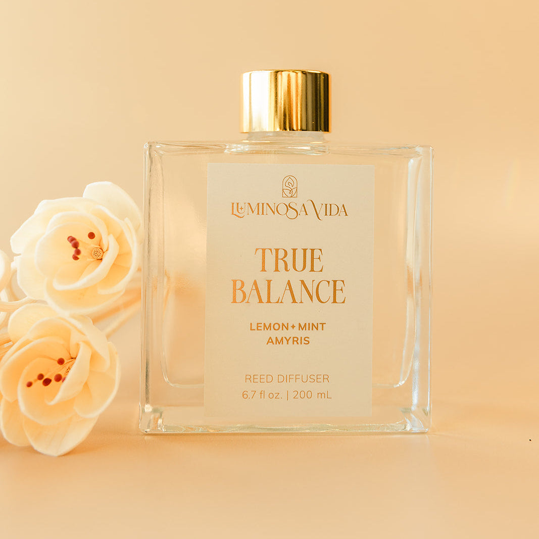Luminosa Vida True Balance reed diffuser with lemon, mint and amyris fragrance in a clear glass bottle with gold lid.