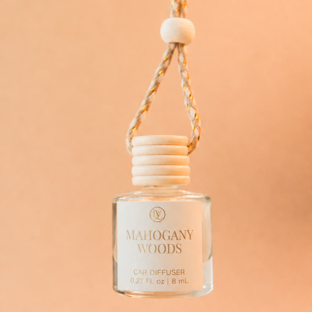 Luminosa Vida Mahogany Woods 8 mL car diffuser in a clear glass bottle with a wooden cap and gold-accented hanging cord.