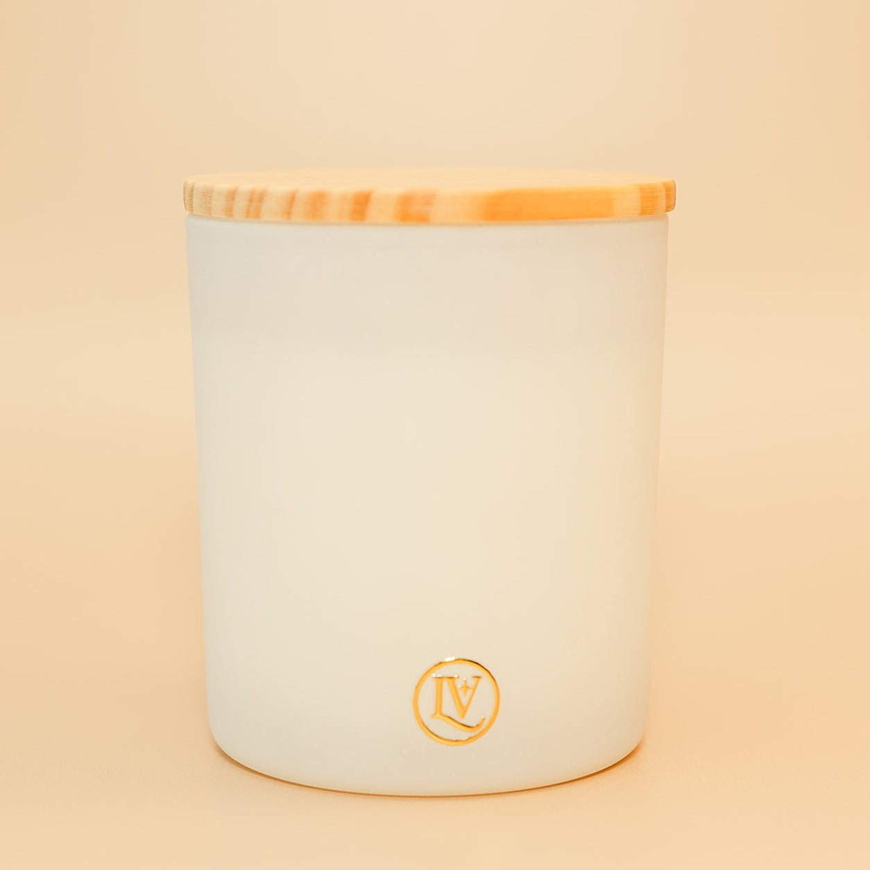 Mahogany Woods coconut wax candle by Luminosa Vida in a white luxury vessel with a natural wood lid, featuring warm notes of red mahogany, cedar, golden apple and lavender.