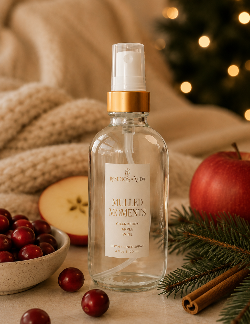 Luxury Mulled Moments room and linen spray featuring cranberry, apple and wine notes styled with holiday décor, evergreen branches, cinnamon sticks and fresh cranberries.
