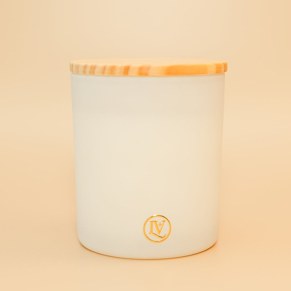 Snowy Evergreens winter candle by Luminosa Vida in a frosted white glass vessel with a wooden lid, featuring notes of pine, cherry blossom, oakmoss, and juniper for a fresh evergreen holiday home fragrance.