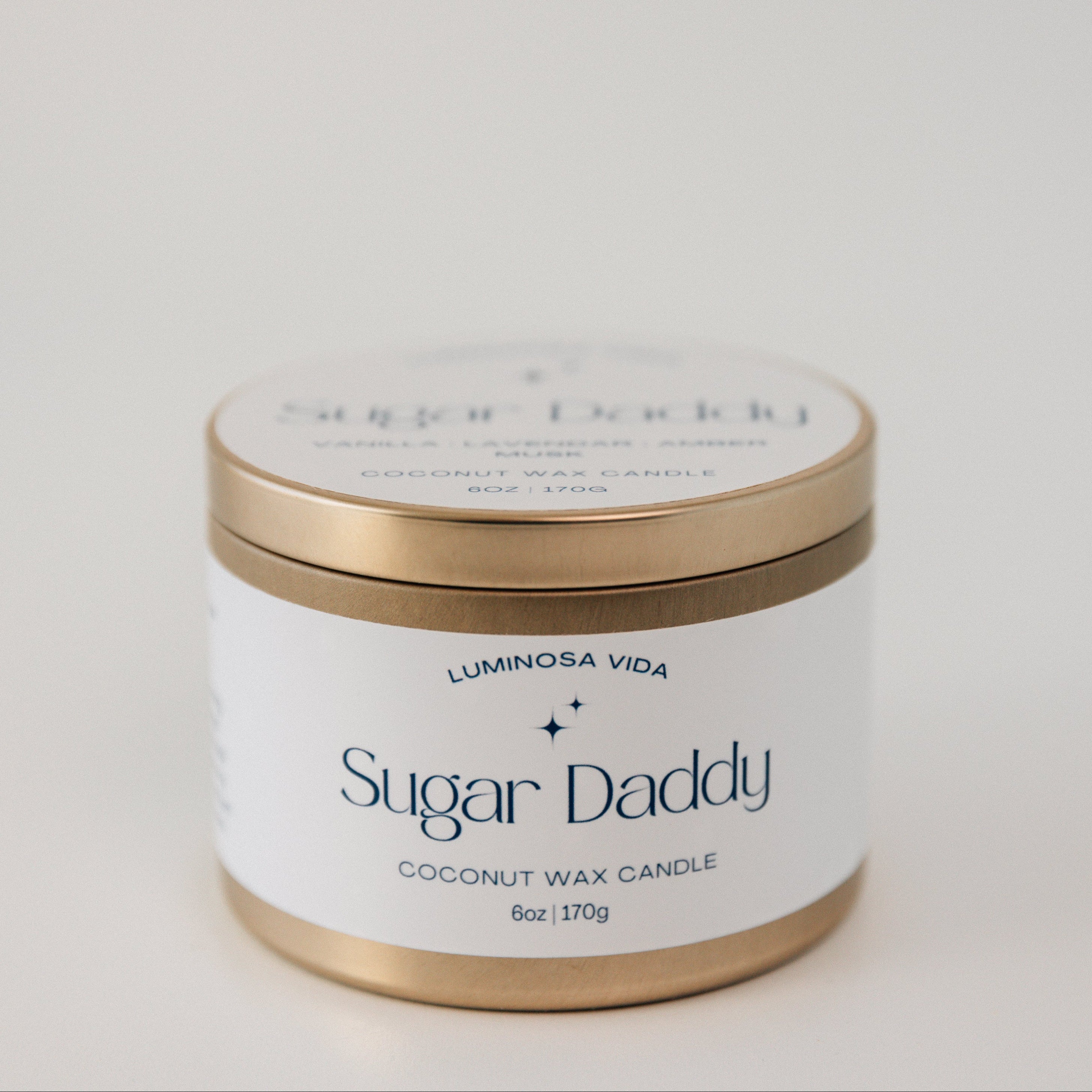 Luxurious candle labeled 'Sugar Daddy,' featuring a rich golden wax in a sophisticated container, styled with opulent accents like gold coins and sweet caramel treats. Perfect for a lavish and indulgent atmosphere.