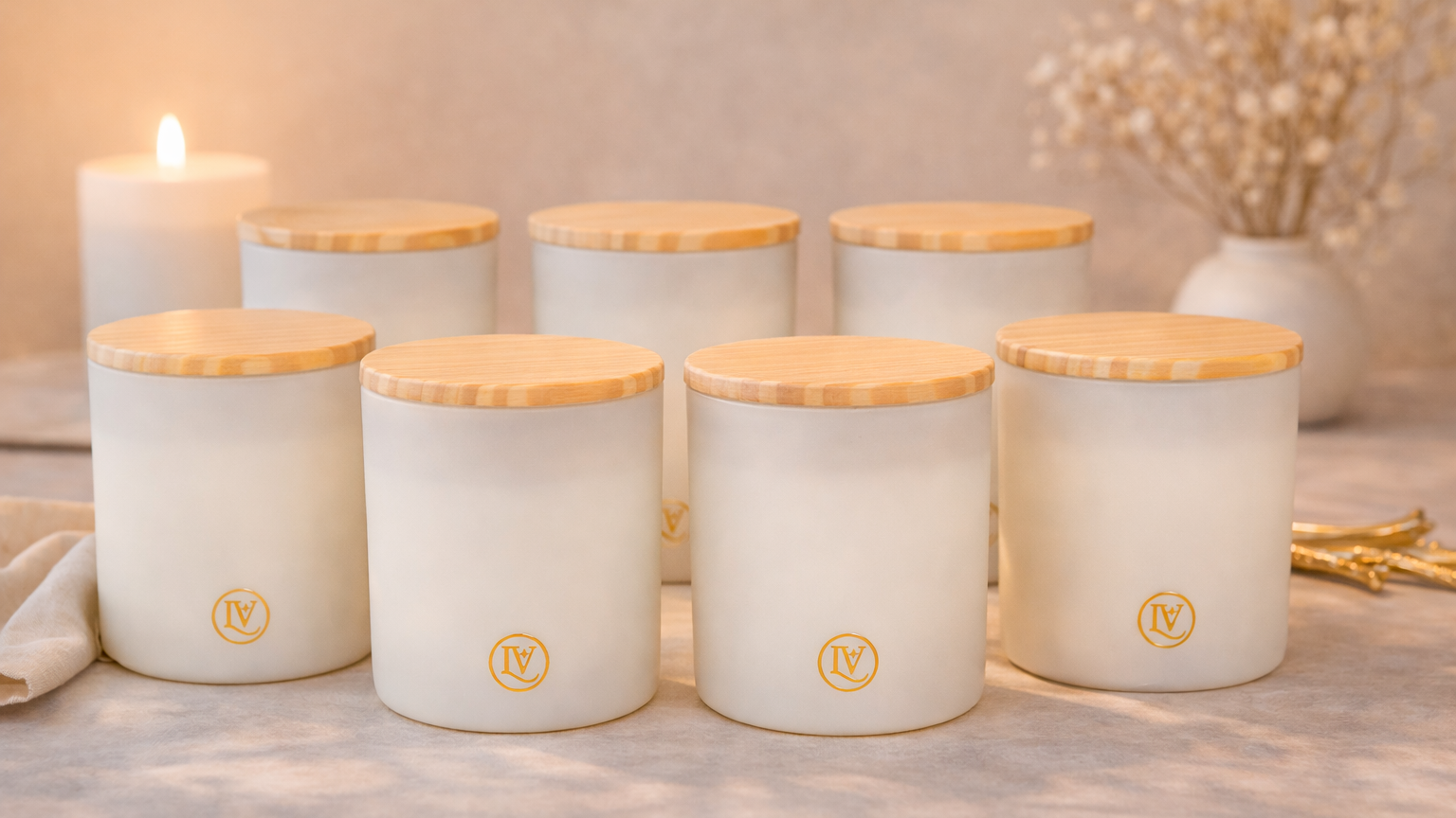 Luminosa Vida luxury candle collection in frosted white glass vessels with wood lids styled in a warm lifestyle scene.