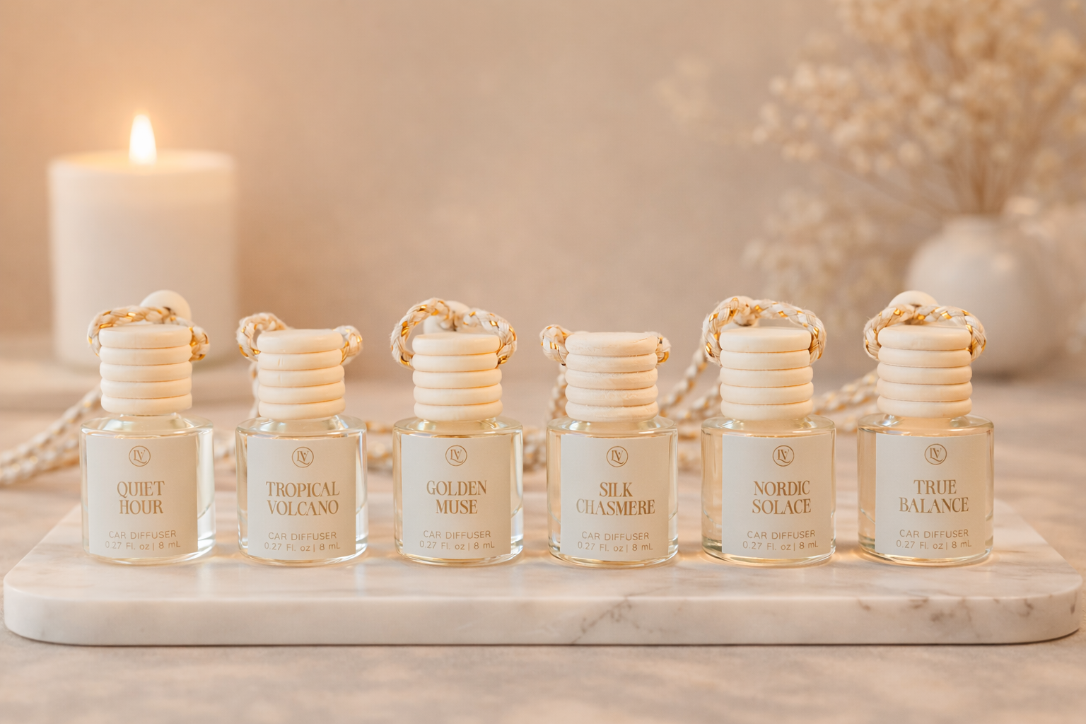 Luminosa Vida luxury car diffuser collection displayed on a marble tray in a warm lifestyle scene.