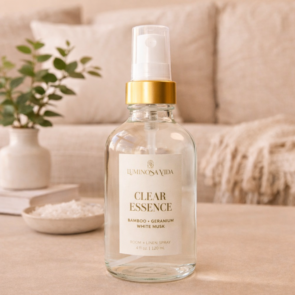 Luminosa Vida Clear Essence room and linen spray with bamboo, geranium, and white musk on a neutral living room coffee table with soft decor and natural light.