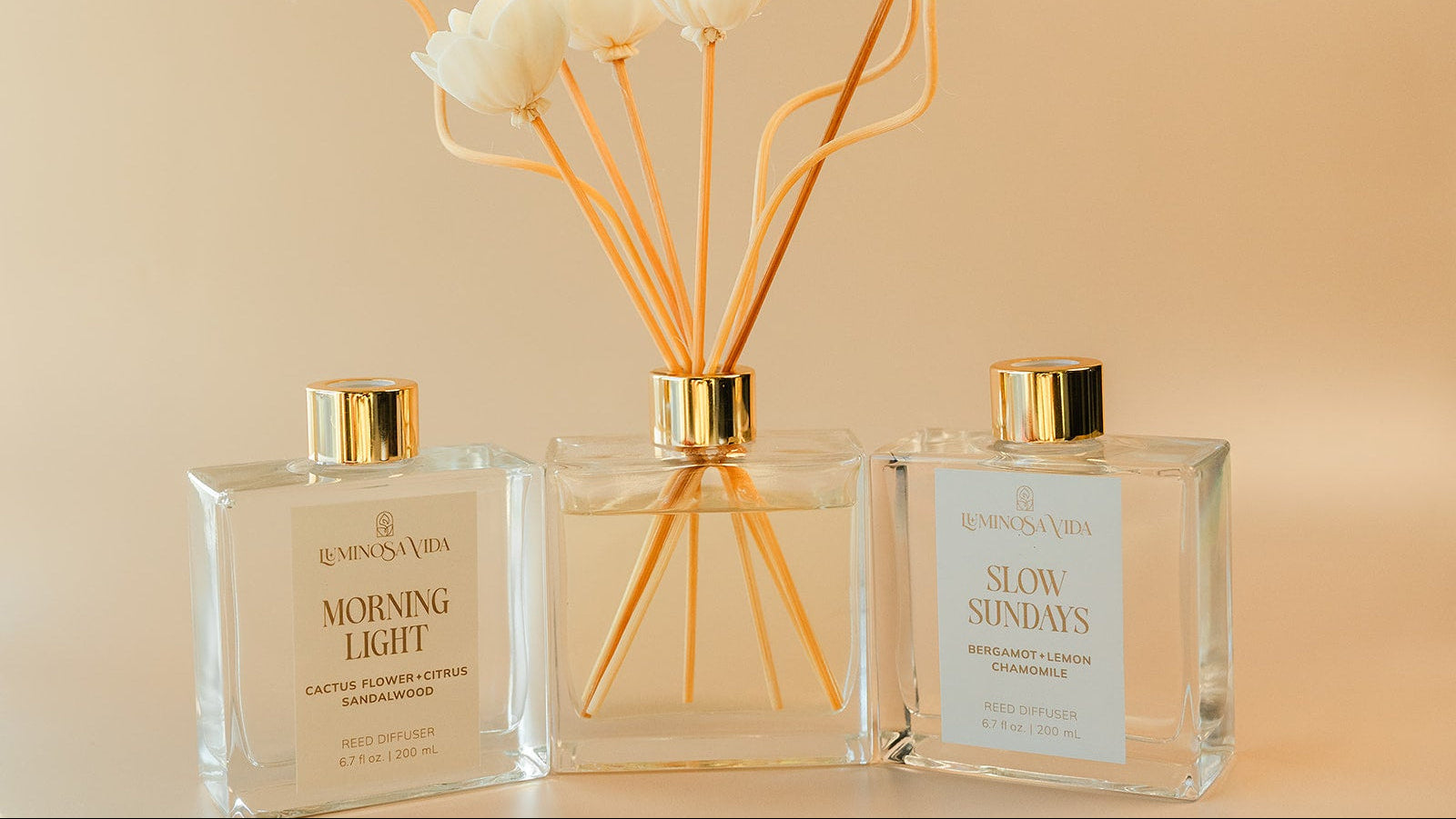 Luminosa Vida luxury reed diffuser collection featuring Morning Light and Slow Sundays fragrances styled in a warm minimalist hero banner.