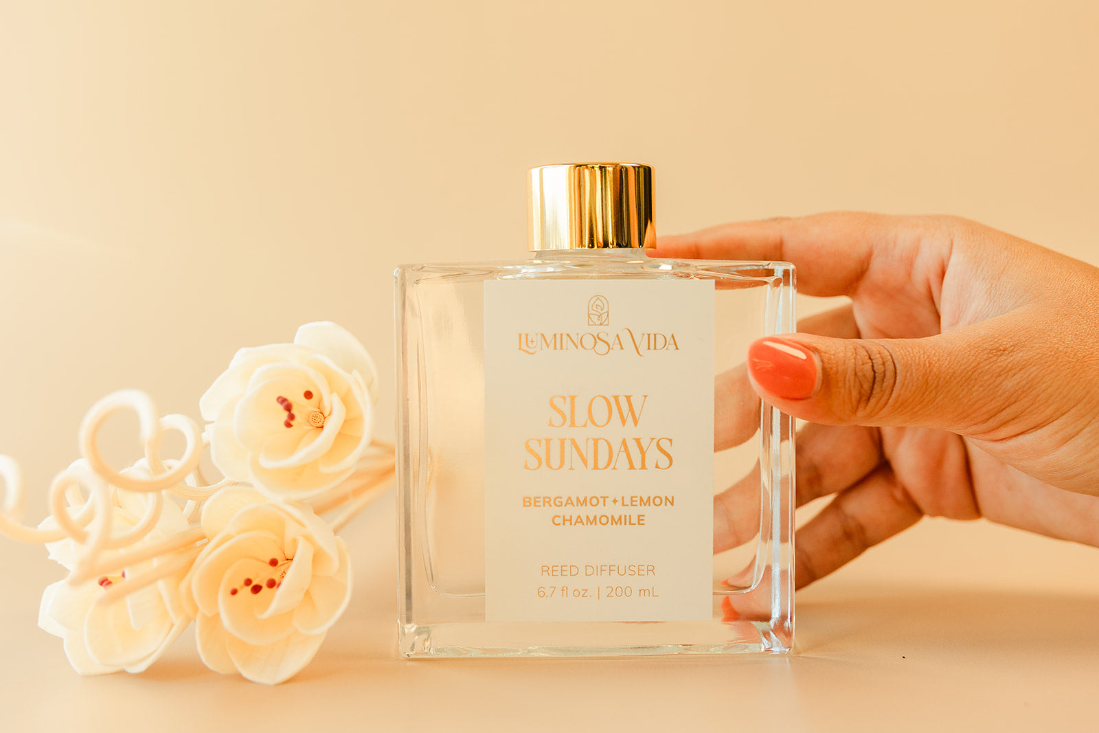 Luminosa Vida Slow Sundays reed diffuser with bergamot, lemon and chamomile fragrance in a clear glass bottle with gold lid.